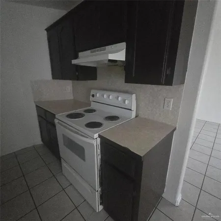 a kitchen with a stove top oven and cabinets