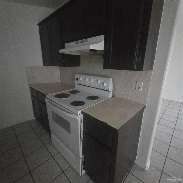 3915 South Alamo Road, Unit 20 Edinburg, TX 78542 - Photo 4 of 14 a kitchen with a stove top oven and cabinets