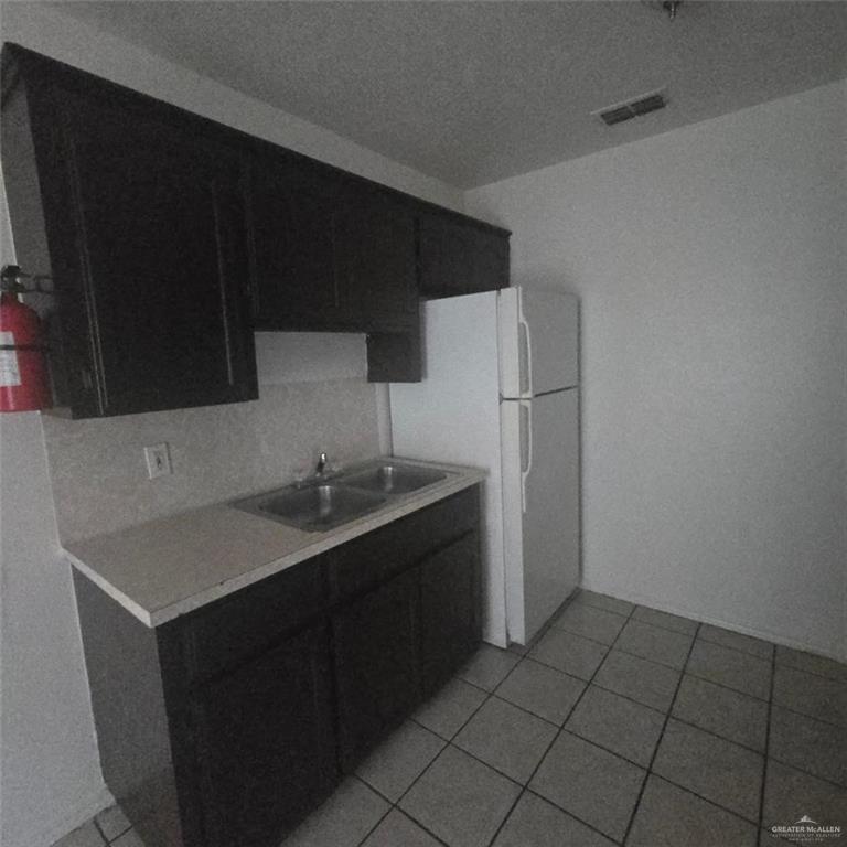 3915 South Alamo Road, Unit 20 Edinburg, TX 78542 - Photo 5 of 14 a kitchen with a sink and a refrigerator