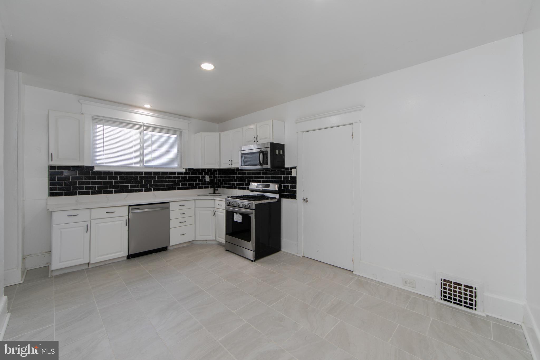 513 Benson Street Camden, NJ 08103 - Photo 12 of 37 a kitchen with a stove a sink and a microwave