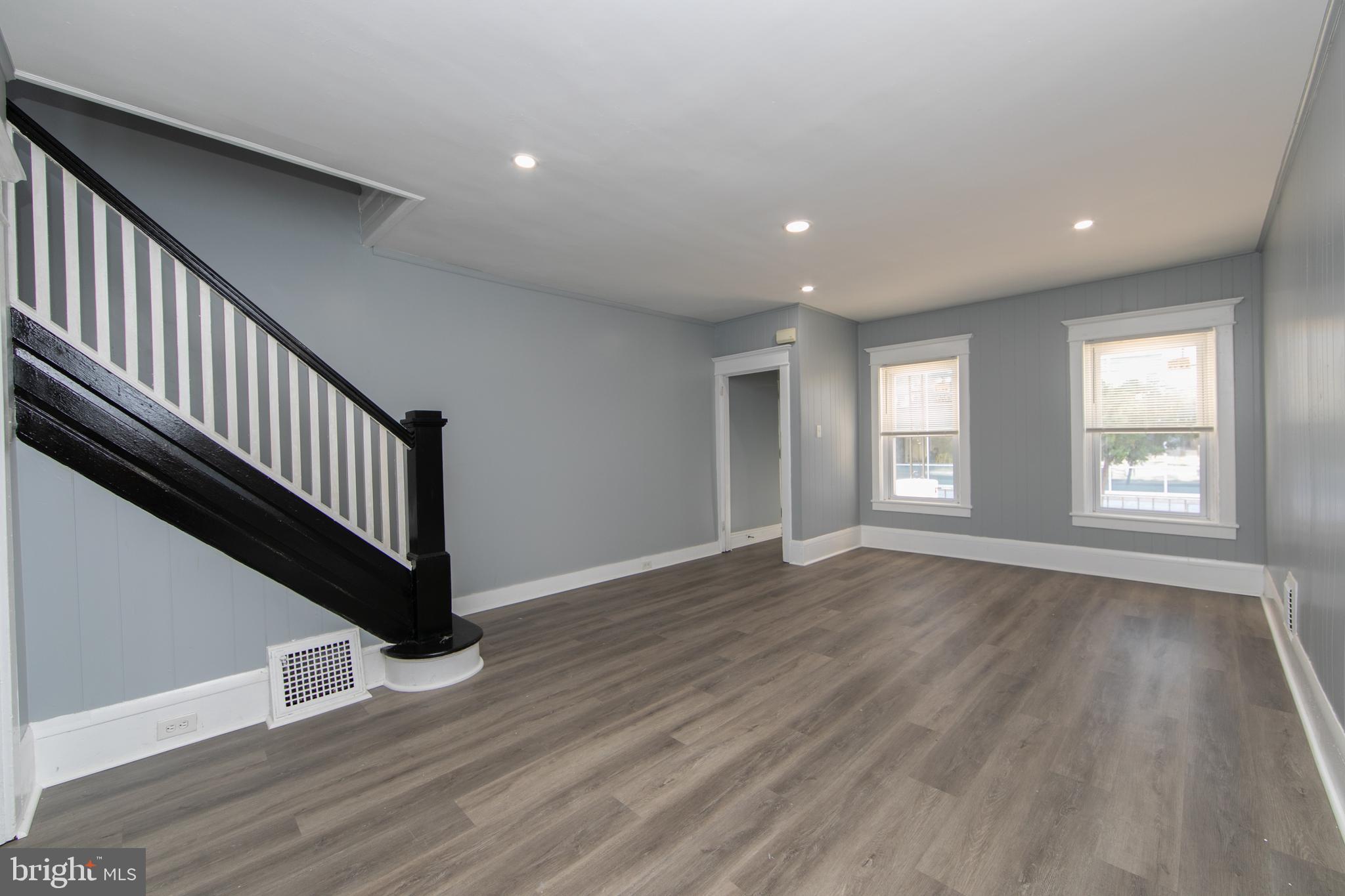 513 Benson Street Camden, NJ 08103 - Photo 4 of 37 a view of an empty room with wooden floor and window