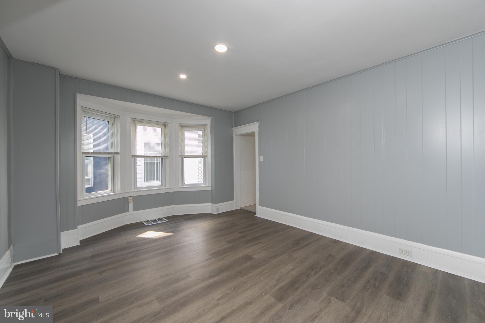 513 Benson Street Camden, NJ 08103 - Photo 5 of 37 a view of an empty room with wooden floor and a window