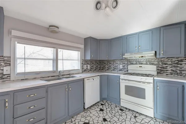 a kitchen with granite countertop white cabinets and white stainless steel appliances