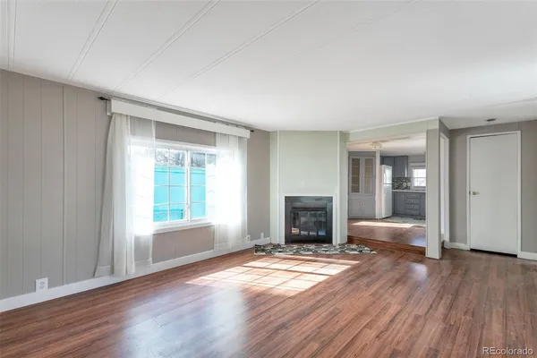 a view of empty room with wooden floor and fireplace