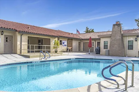 a view of a house with swimming pool and sitting area
