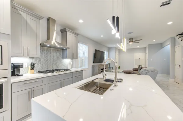 a kitchen with stainless steel appliances kitchen island a sink stove and cabinets