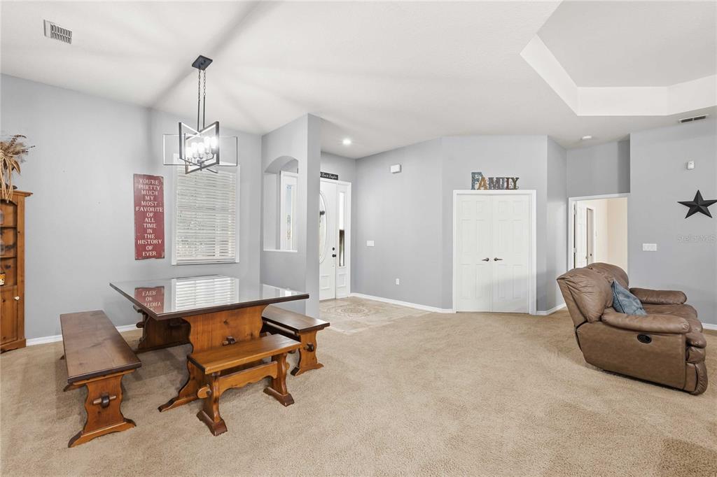 34106 Trilby Road Dade City, FL 33523 - Photo 22 of 39 a living room with furniture and a chandelier