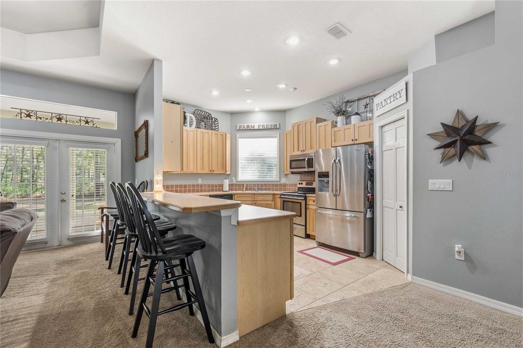 34106 Trilby Road Dade City, FL 33523 - Photo 24 of 39 a kitchen with refrigerator a table and chairs