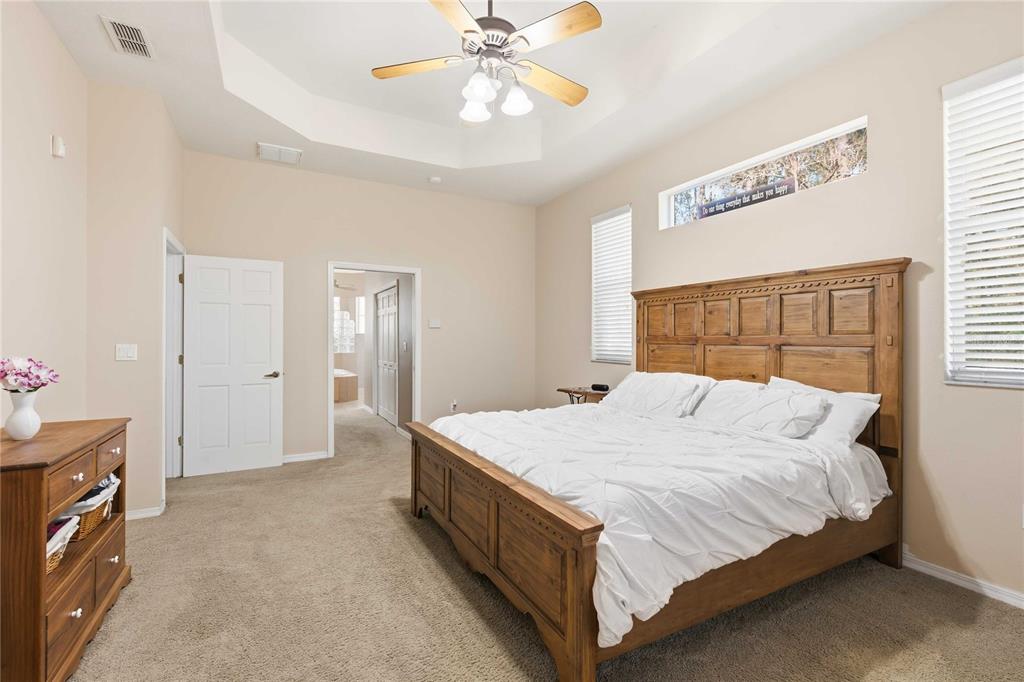 34106 Trilby Road Dade City, FL 33523 - Photo 28 of 39 a bedroom with a bed and a chandelier