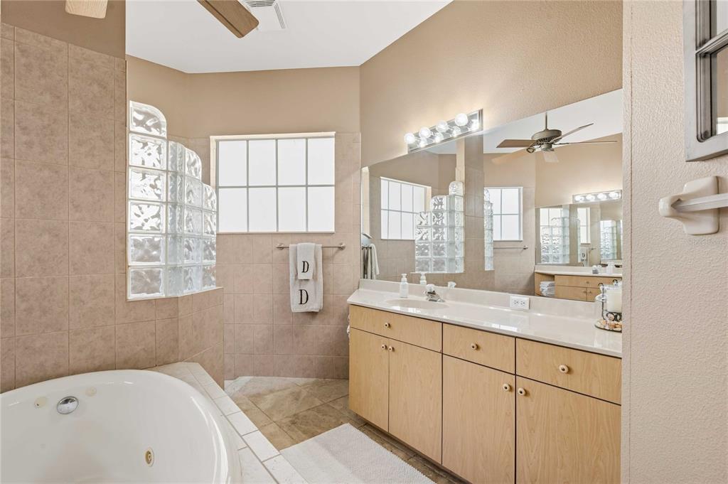 34106 Trilby Road Dade City, FL 33523 - Photo 29 of 39 a bathroom with a granite countertop sink mirror and a bathtub