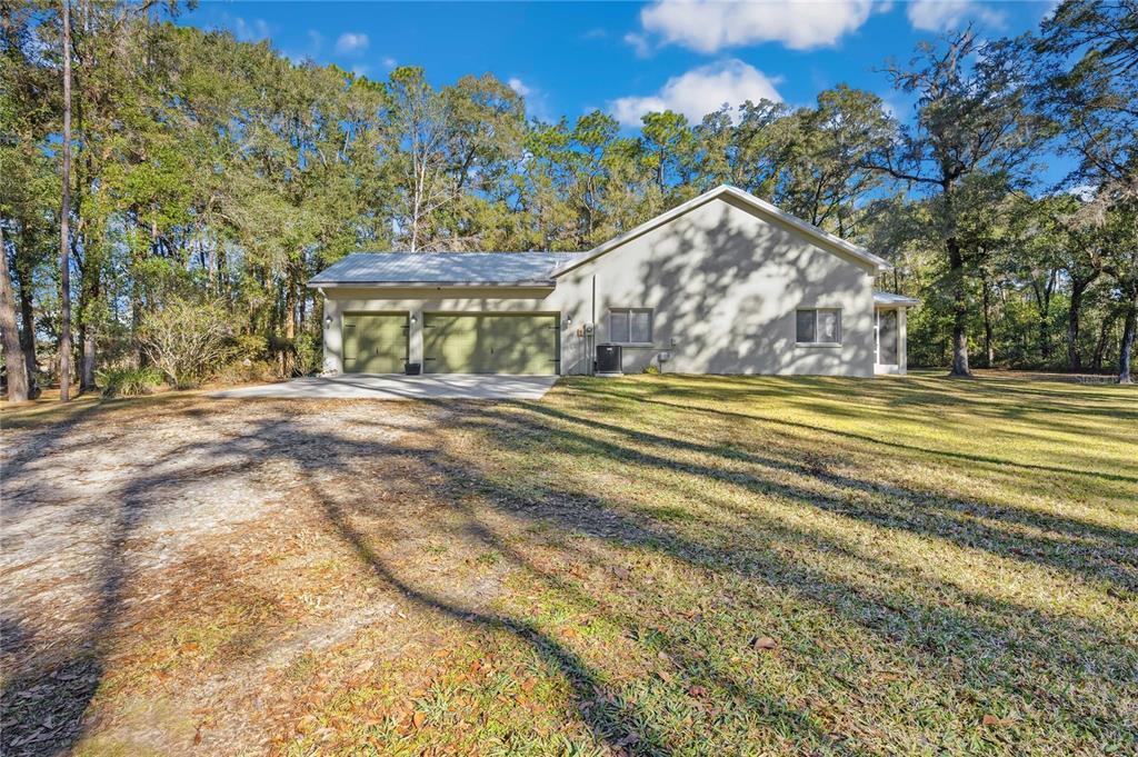 34106 Trilby Road Dade City, FL 33523 - Photo 32 of 39 a view of a house with a big yard and large trees