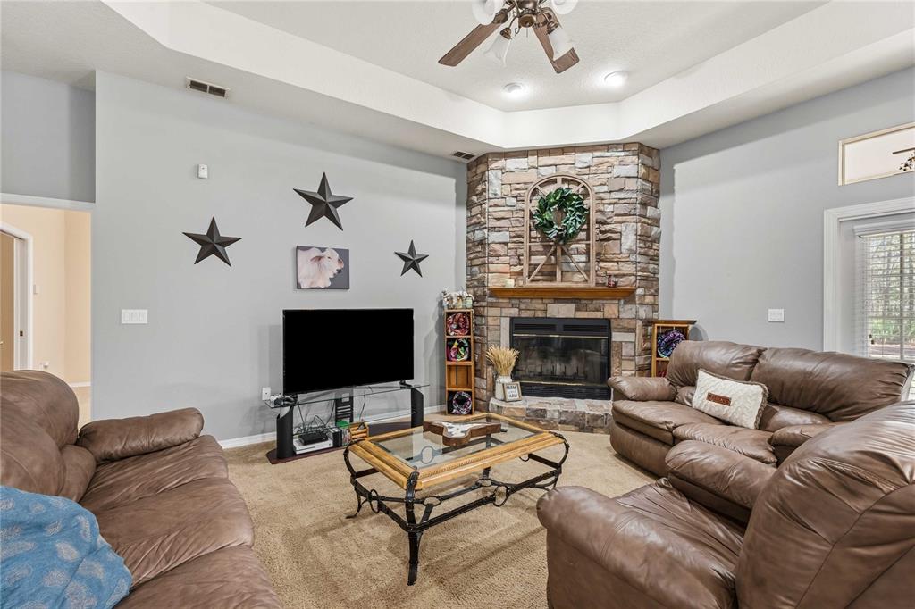 34106 Trilby Road Dade City, FL 33523 - Photo 4 of 39 a living room with furniture a fireplace and a flat screen tv