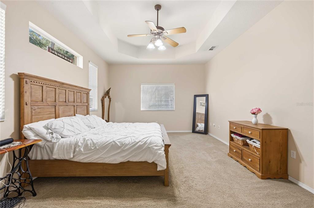 34106 Trilby Road Dade City, FL 33523 - Photo 6 of 39 a bedroom with a bed and a chandelier