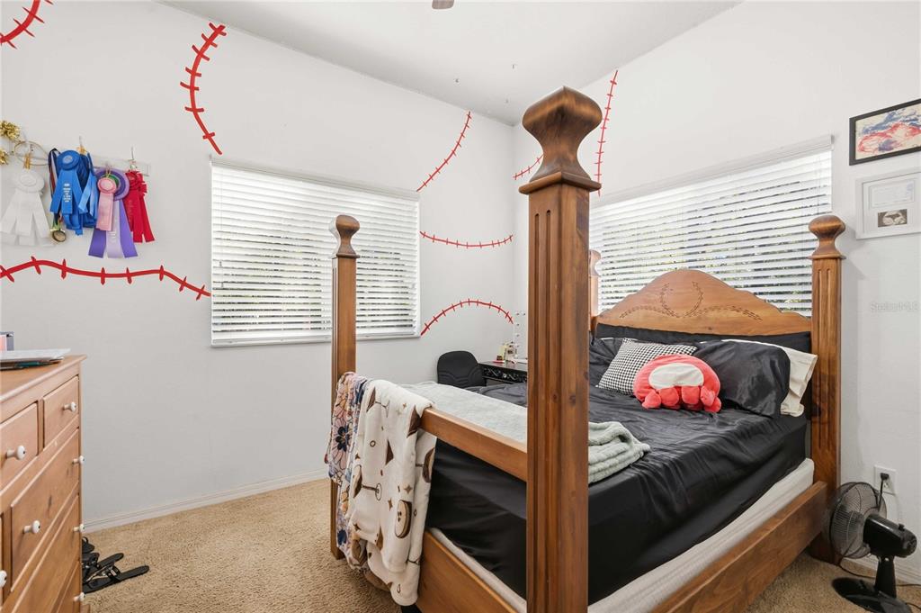 34106 Trilby Road Dade City, FL 33523 - Photo 9 of 39 a bedroom with a bed and a chandelier