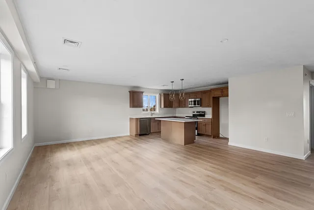 a view of kitchen with wooden floor and electronic appliances