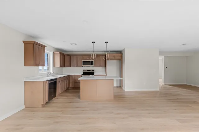a kitchen with stainless steel appliances a sink a stove top oven and white kitchen