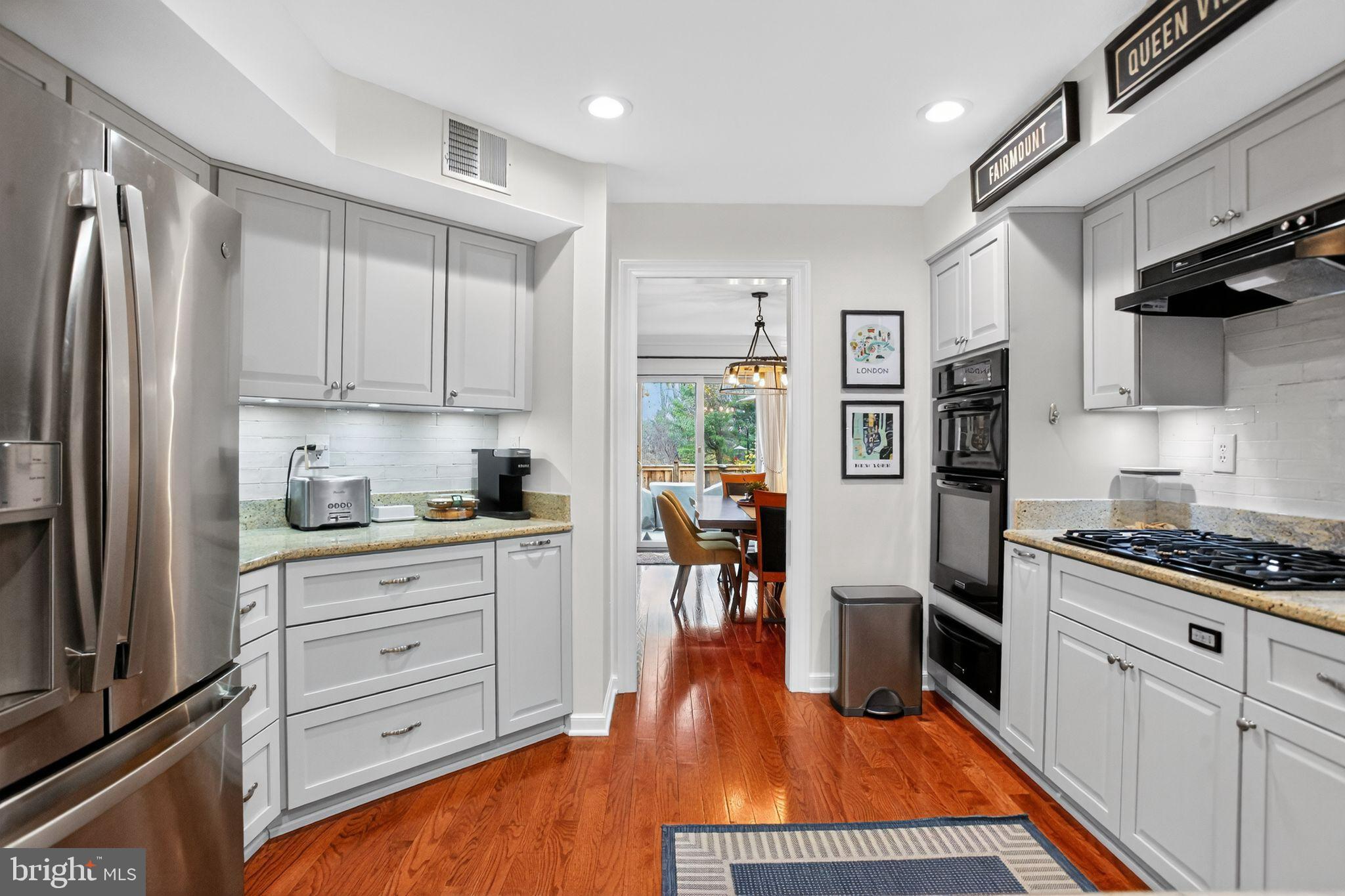 149 Splitrail Lane Blue Bell, PA 19422 - Photo 12 of 40 a kitchen with stainless steel appliances granite countertop a refrigerator stove oven and white cabinets with wooden floors
