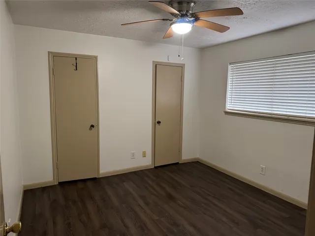 an empty room with wooden floor and a window