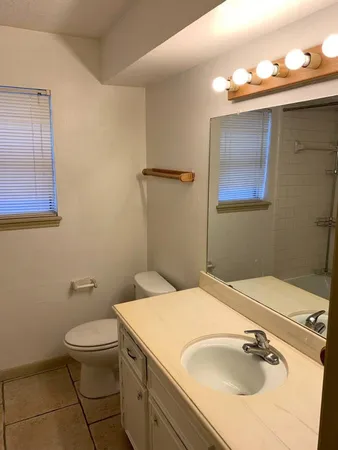 an empty room with a window and ceiling fan