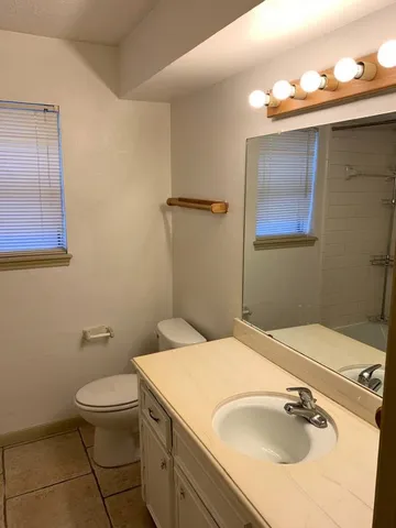 an empty room with a window and ceiling fan