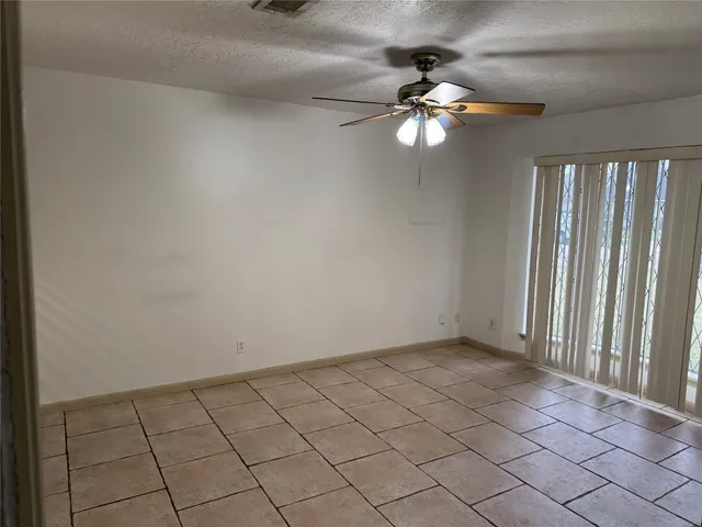 an empty room with wooden floor a ceiling fan and closet