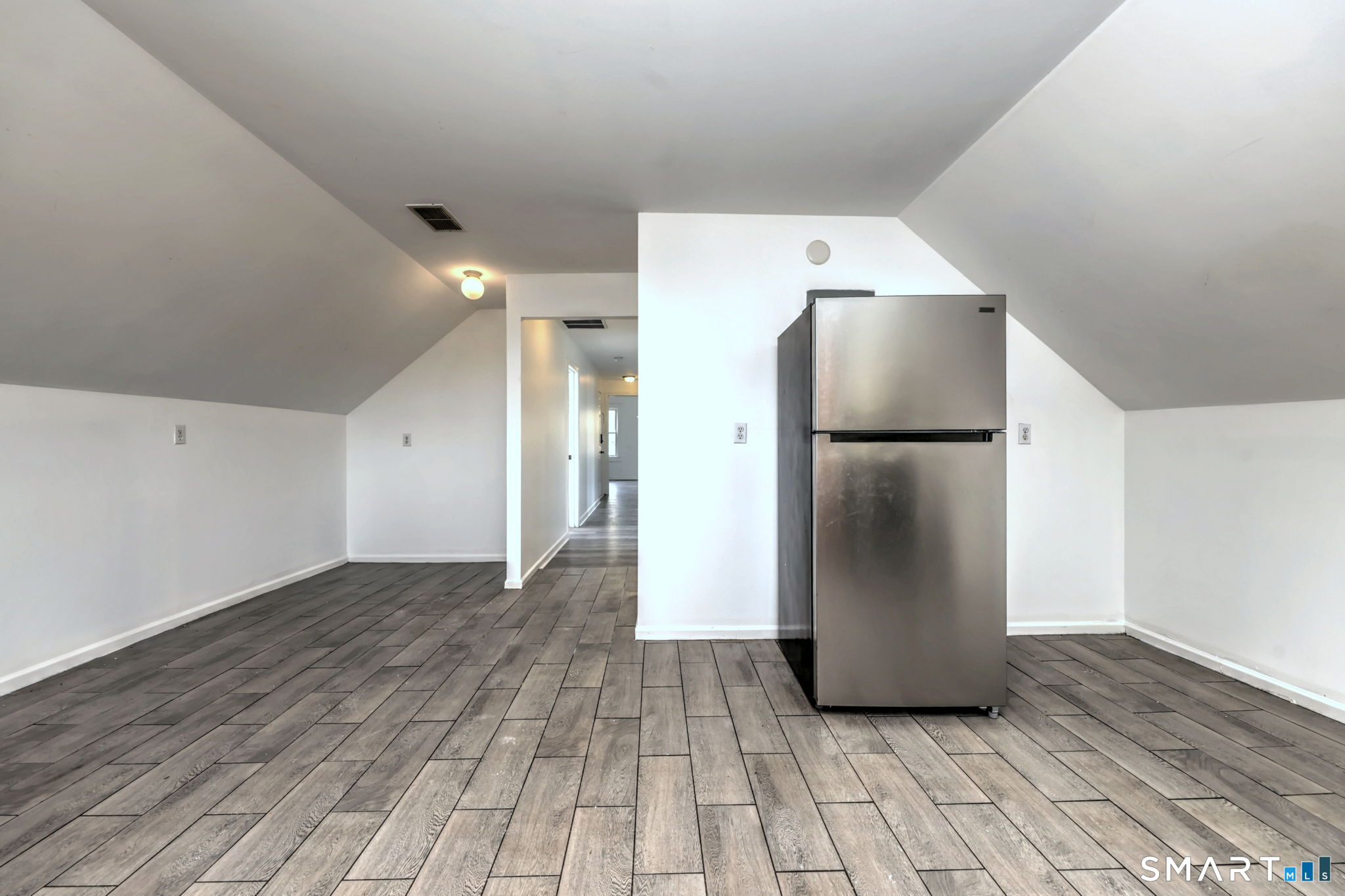 483 Ferry Street, Unit 3 New Haven, CT 06513 - Photo 24 of 28 a view of a refrigerator in kitchen and an empty room with wooden floor