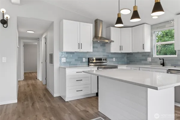 a kitchen with stainless steel appliances a sink stove and cabinets