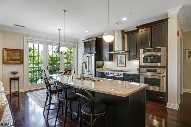 a kitchen with granite countertop a table chairs stove and refrigerator