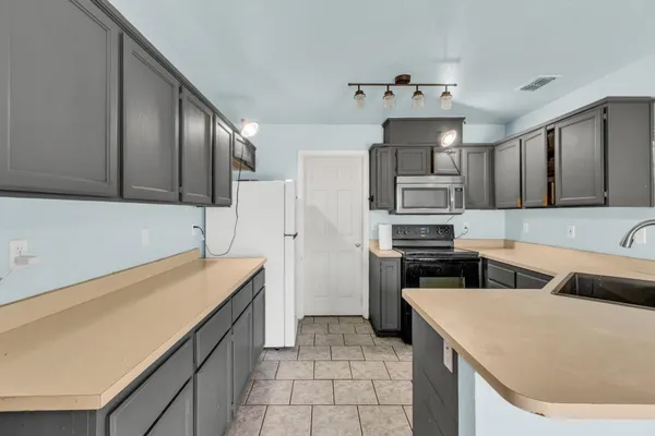 a kitchen that has a cabinets and steel appliances