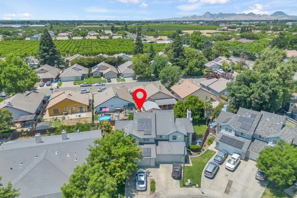 an aerial view of a city with lots of residential buildings ocean and mountain view in back