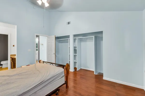 a bedroom with a bed and wooden floor