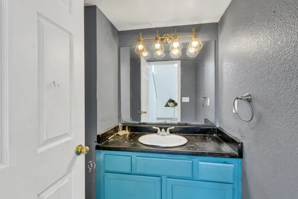 a bathroom with a granite countertop sink and a mirror