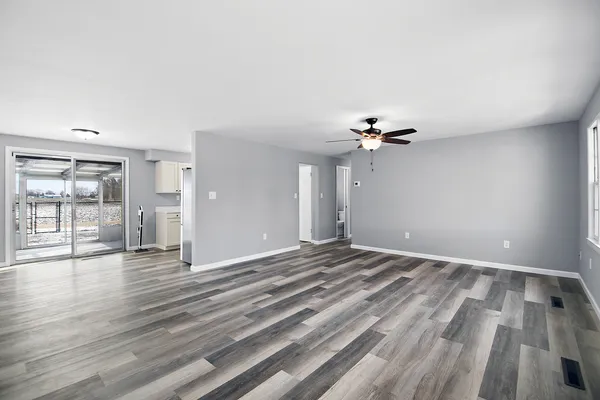 a view of a livingroom with wooden floor and a ceiling fan