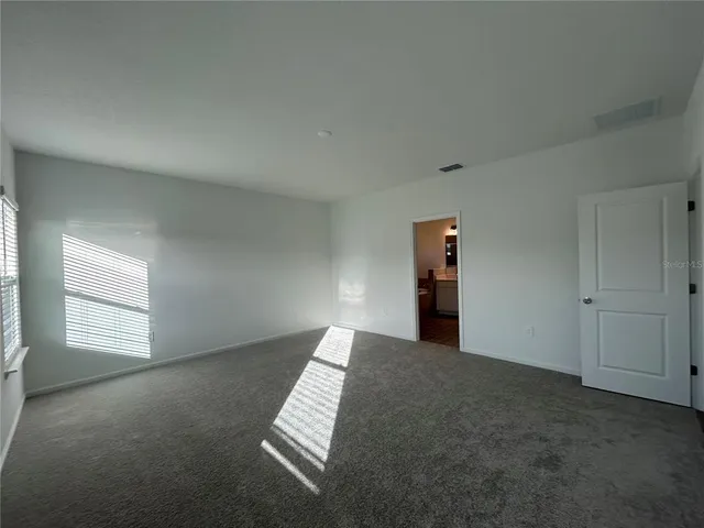 an empty room with windows and cabinet