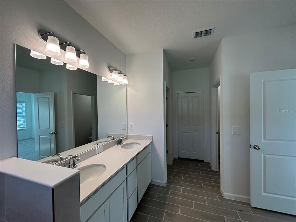 12419 Northwest 139th Court Alachua, FL 32615 - Photo 17 of 38 a bathroom with a double vanity sink and a mirror