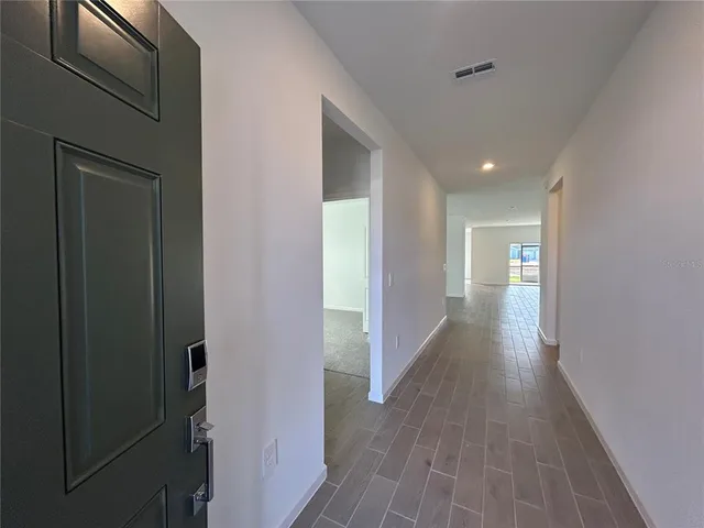 a view of a hallway with wooden floor