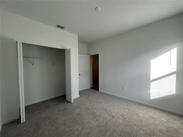 an empty room with windows and closet