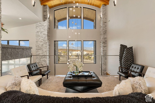 3652 South Cypress Road Hurricane, UT 84737 - Photo 35 of 81 Two-story living area featuring stacked stone accent walls, a vaulted wood-paneled ceiling, and large windows with arched transoms