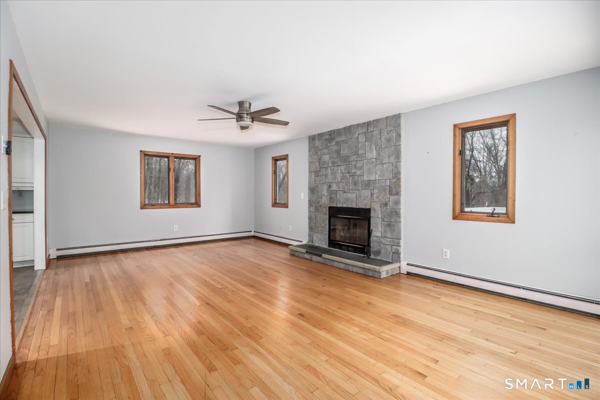 8 Pebble Lane New Milford, CT 06776 - Photo 9 of 44 a view of an empty room with wooden floor and a window