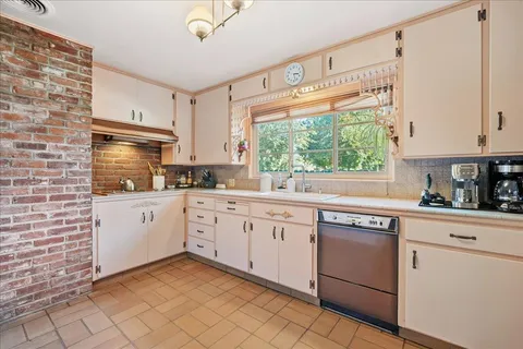 a kitchen with white cabinets and white appliances