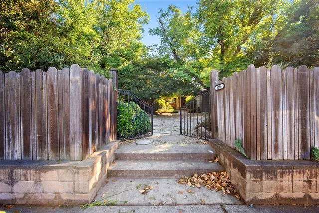 a view of a pathway of a house with wooden fence