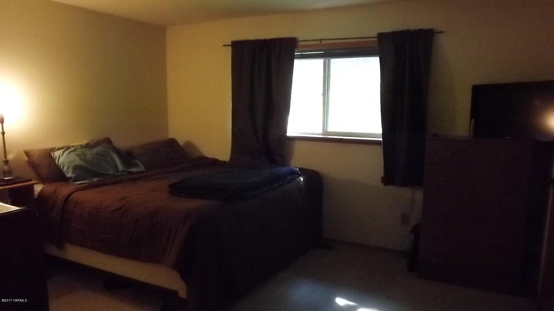 8401 North Missimer Road Prosser, WA 99350 - Photo 12 of 13 a bed sitting in a bedroom next to a window