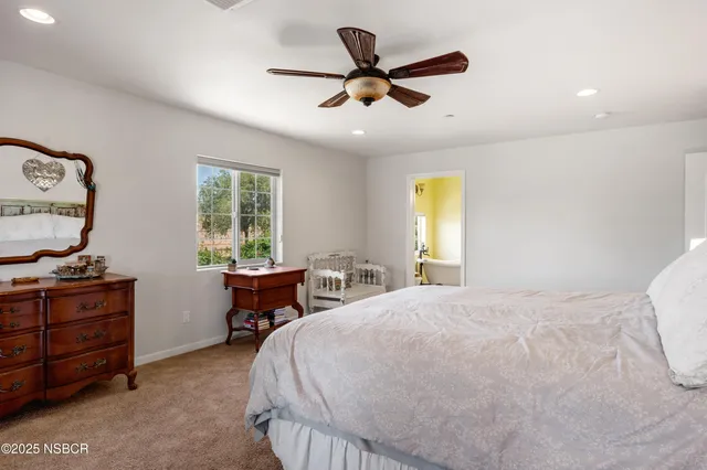 a bedroom with a bed and a dresser next to a window