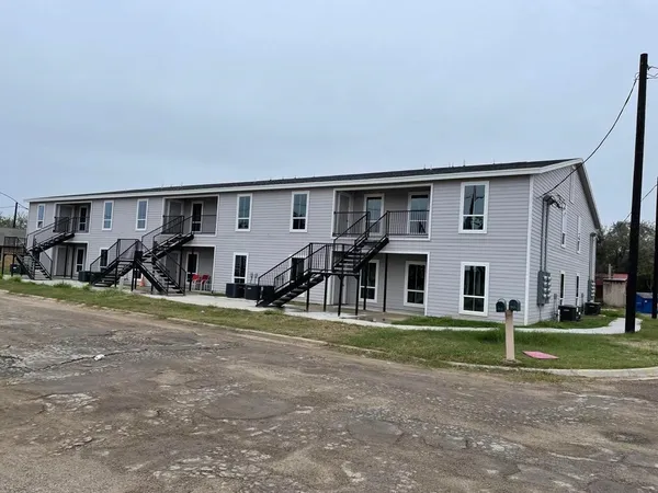 a view of a house with backyard and a tree