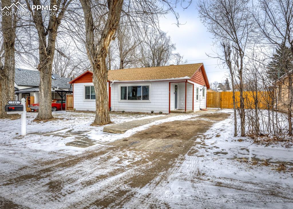 a backyard of a house with fire pit and trees