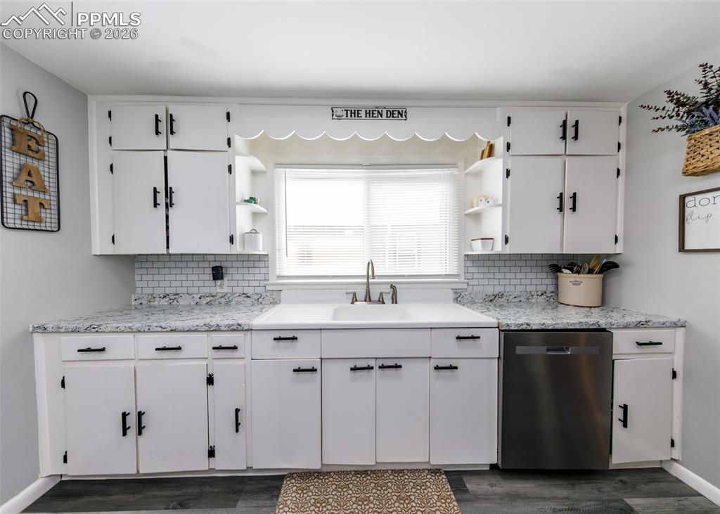 548 Denver Street Calhan, CO 80808 - Photo 11 of 40 a kitchen with granite countertop a sink window and cabinets