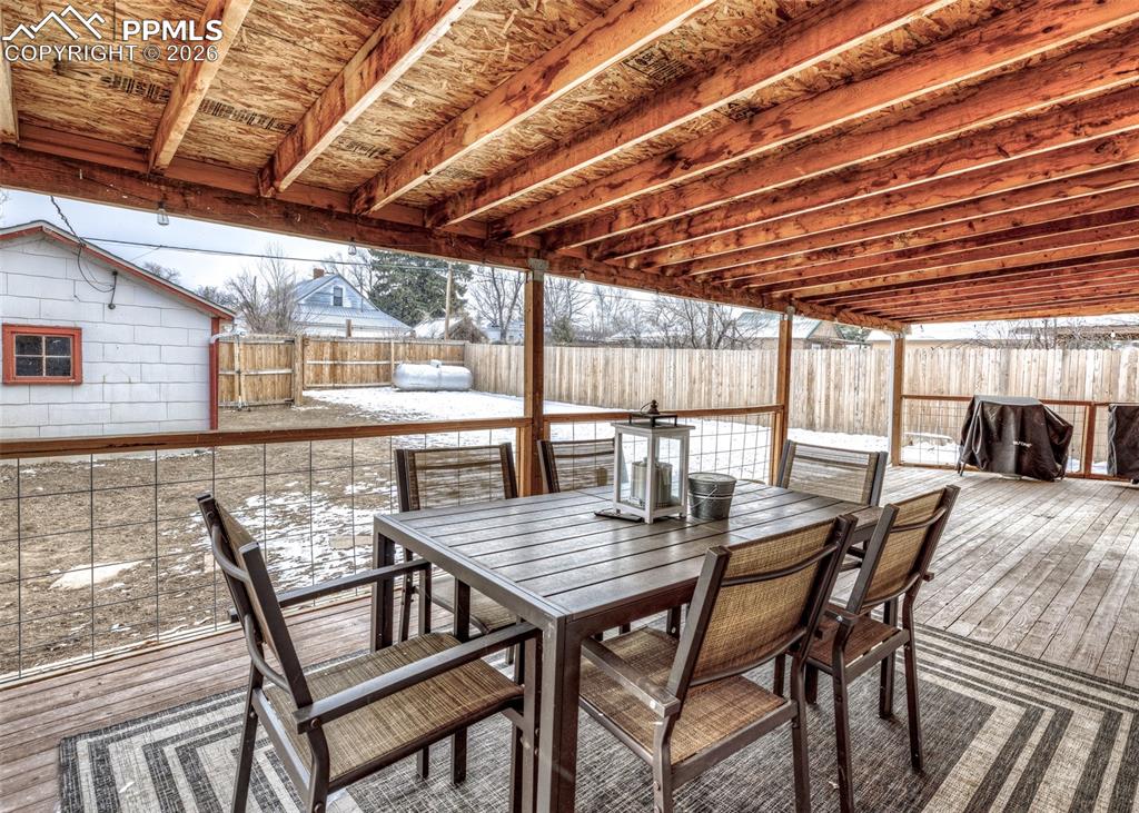 548 Denver Street Calhan, CO 80808 - Photo 34 of 40 a view of a patio with table and chairs with wooden floor and fence