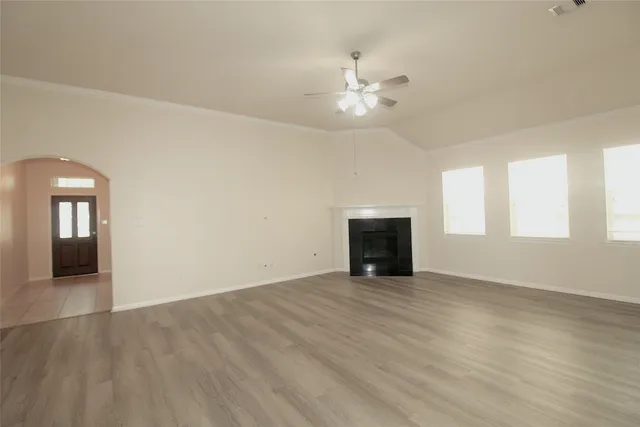 an empty room with windows and fireplace