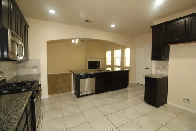 a large kitchen with a stove a sink and a microwave