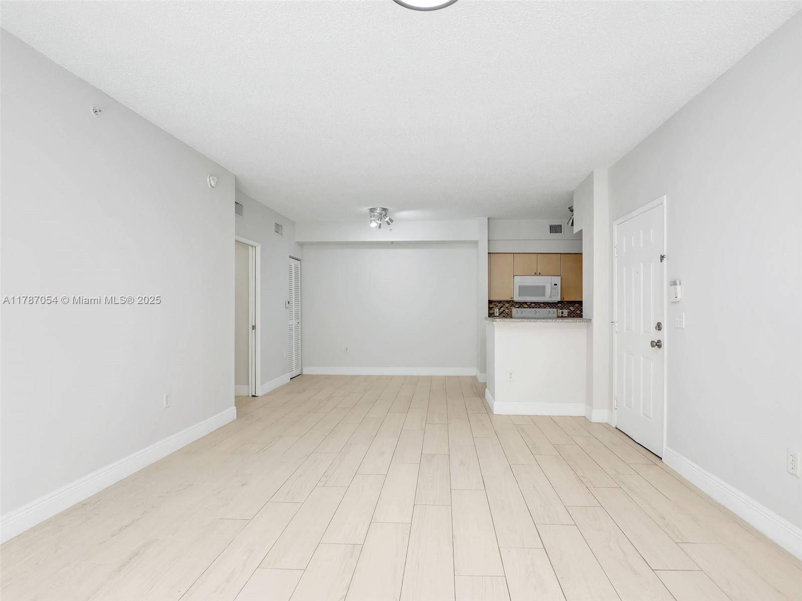 1235 Reserve Way, Unit 5107 Naples, FL 34105 - Photo 23 of 27 a view of empty room with wooden floor